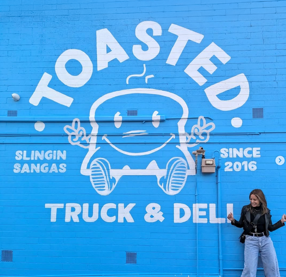 Stylized blue and pink image of a whiskey glass with the wordmark of Vèloce in pink all-caps letters above.